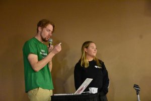 Students Collin Brault and Morgaine Prather read off winning raffle tickets at a trivia night event hosted in the Titan Underground.