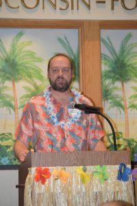 UW Oshkosh Chancellor Andrew Leavitt speaks at the fundraiser dressed in a Hawaiian shirt and luau in order to fit the tropical island theme.