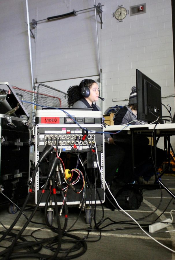Titan TV Programming Director Crystal Perez runs audio and graphics at a basketball game.