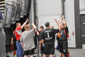 North Suburban players and coaches high-five in celebration of a well-played game.