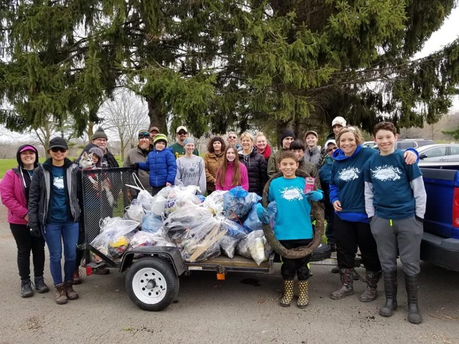 Some of the 1,100 Fox-Wolf Watershed volunteers pose with collected garbage by the Fox River on April 27.