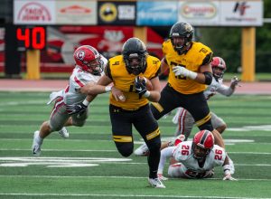 UW Oshkosh junior tight end Justin Kasuboski breaks away from a pair of Carthage defenders in the Titans’ 20-19 victory on Saturday. Kasuboski caught two passes for 31 yards in the season opener. 