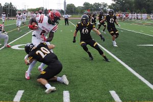 UWO senior defensive back Calvin Shilling (20) tackles Huntingdon quarterback Otis Porter (2) while UWO linebacker Nick Noethe approaches in pursuit. Shilling recorded three total tackles in the 44-14 victory for the Titans. 