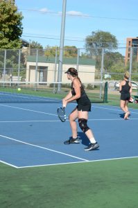 Junior Kelly Hodyl (front), sophomore Michelle Spicer (middle) and junior Lesley Kutnink (back) face off against their respective UW-Stevens Point opponents at the Kolf Sports Center outdoor tennis court on Sept 26.