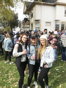 Lauren (middle) cracks open a beer with her roommates Katie (left) and Payton (right) at Pub Crawl.