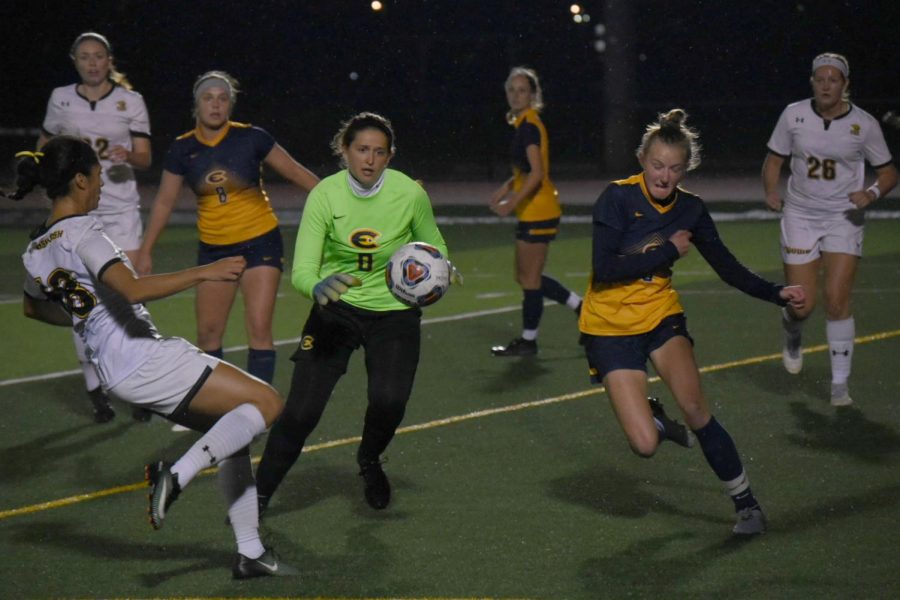 Senior Madison Smith approaches UW-Eau Claire defenders while two of her teammates look on. 
