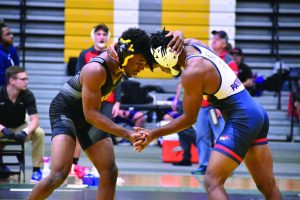 Sophomore Kobe Allen grapples with a opposing wrestler during the Dan Gable Open on Nov. 9. UWO lost to UW-Eau Claire on Saturday 25-9, making them 0-2 in WIAC competition. 