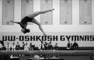 Courtesy of UW Oshkosh Photoshelter Junior Paige Mayhew  performs an aerial on the balance beam at a home meet on Jan. 17, 2020. 