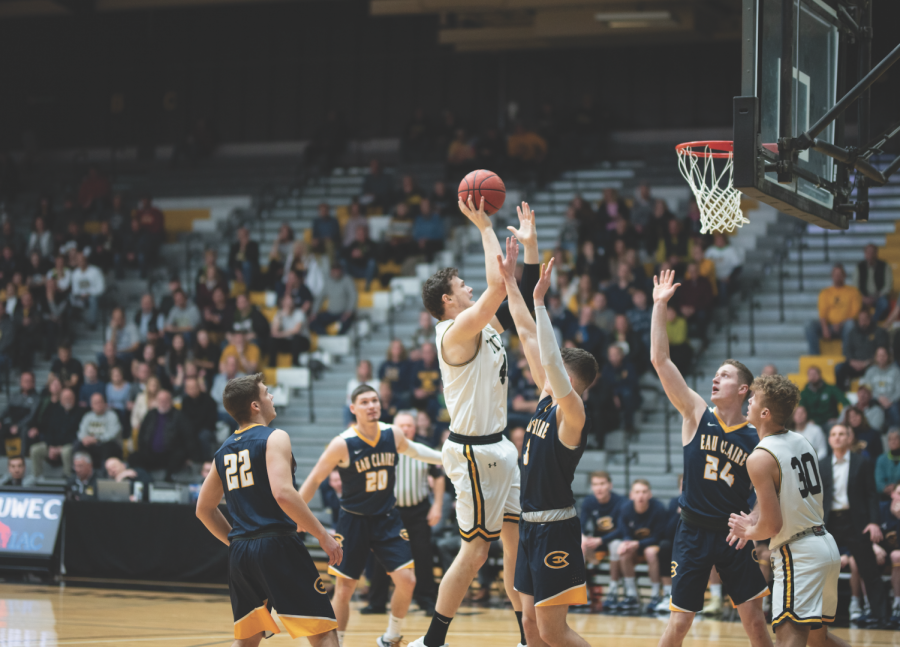 Senior center Jack Flynn tosses up a floater over UW-Eau Claire forward Spencer Page in UW Oshkosh’s 78-72 WIAC Championship home victory on Feb. 29. Flynn put up 19 points, eight rebounds and one assist. The Titans will ride their seven-game winning streak into Naperville, IL to play Transylvania University. 