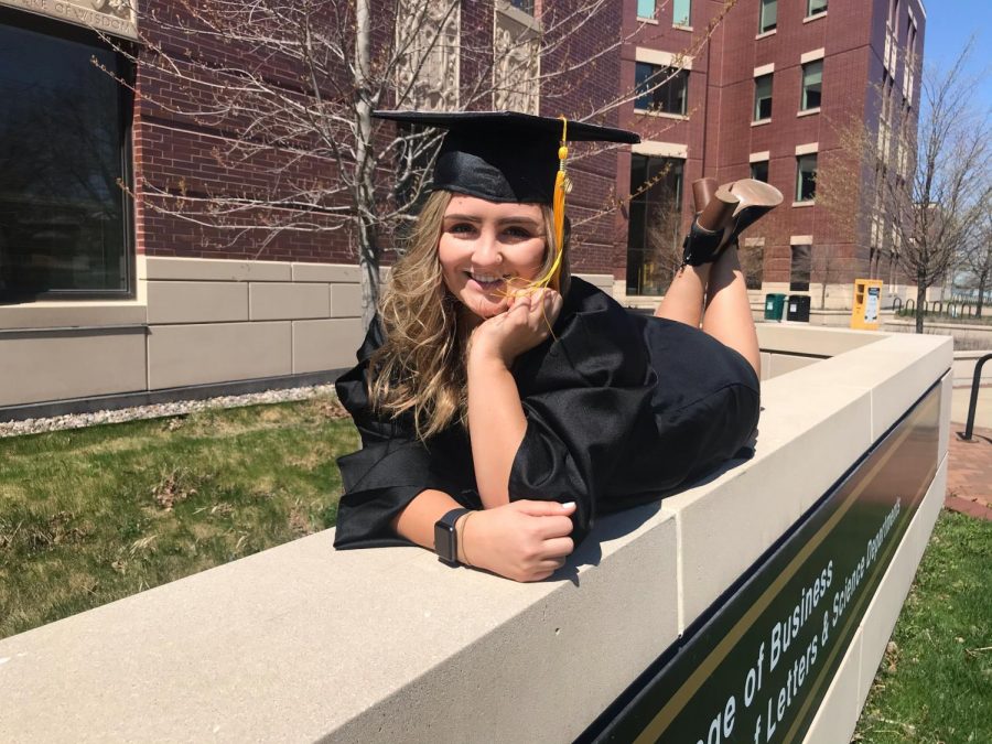 Lauren sitting on the Sage Hall sign, as majority of her Journalism classes were here.