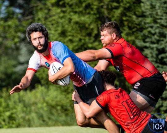 Photo creds: Bill Blake / Oshkosh Rugby Club-- Brad Gorzek dives in order to advance past the tackling opposition. In Rugby, anyone can run the ball, allowing for greater diversity of strengths.