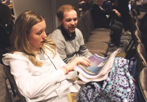 Katie Pulvermacher/The Advance-Titan — Second-year student Anya Kelley and fourth-year student Owen Peterson sit in a session at MediaFest22 and look through a copy of The Advance-Titan after learning tips on how to craft a successful newspaper.