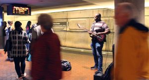 Katie Pulvermacher/The Advance-Titan — A performer plays his guitar in the metro while tourists and locals rush between platforms.