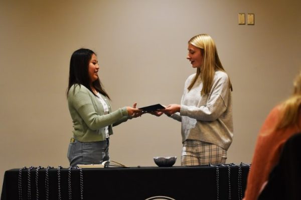 Kelly Hueckman / Advance-Titan - Ashley Hooyman helps hand out each certificate and pin to the inductees during the ceremony. Hooyman is a first-gen student herself and found community in Tri-Alpha. 
