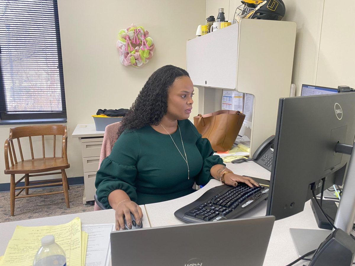 Kelly Hueckman/ Advance-Titan - (Left) Buxton looks over emails in her office. (Right) Buxton wears a bracelet that says 1908, the year Alpha Kappa Alpha was established. Buxton was a member as an undergrad, and wears the bracelet to remind herself of her involvement on campus. 