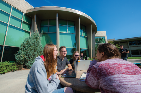 Courtesy of UWO Flickr
Students sit around a table outside of the Fond du Lac campus. Though in-person classes will halt at the campus, the campus will still provide online classes to
students.