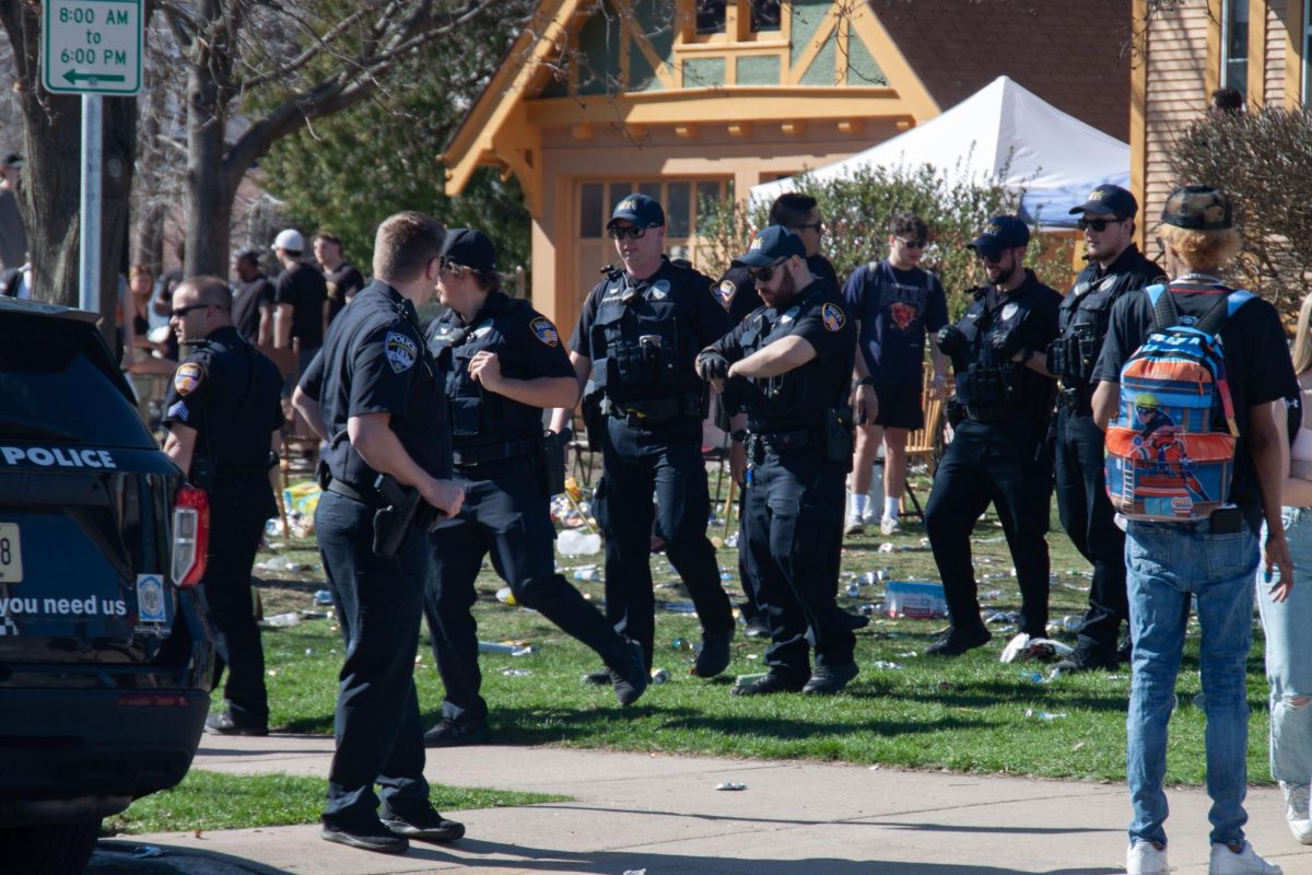 Jess Duch / Advance-Titan 
Officers of the Oshkosh Police Department investigate a party on Amherst Avenue during the spring edition of Pub Crawl Saturday.