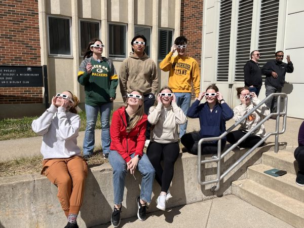 Anya Kelley / Advance-Titan
UWO students with solar eclipse glasses on their faces gather outside of Halsey Science Center to get a view of the partial eclipse in Oshkosh
