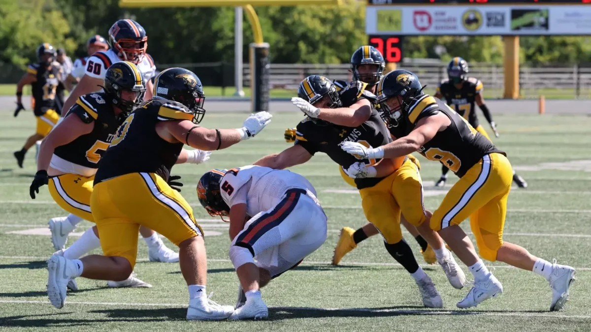 Steve Frommell / UWO Athletics - Four Titans tackle Wheaton's quarterback in UWO's 21-14 win Aug. 7 at Titan Stadium.