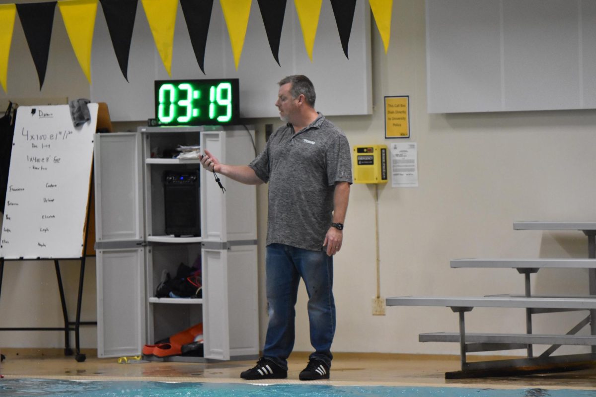 UWO women’s swim and dive head coach Christopher Culp times swimmers as they practice the 4x100 meter relay Nov. 19. 