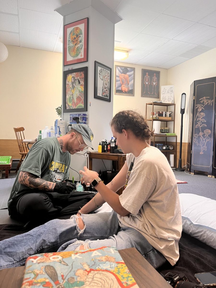 Emma gets a vine tattoo hand-poked by Taylor at his studio.