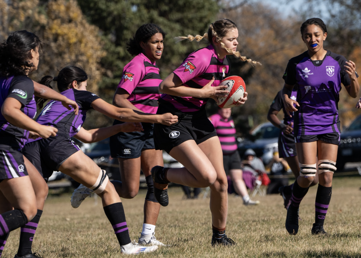 A UW Oshkosh rugby player attempts to get away from a group of Northwestern University players while in posession of the ball during the fall 2024 season. 