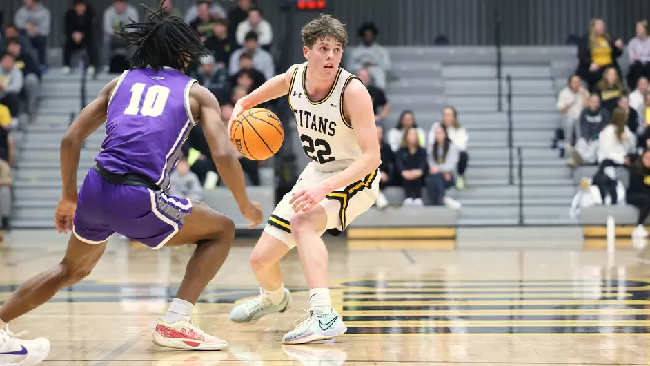 Courtesy of Steve Frommell / UWO Athletics -- UWO's Reed Seckar crosses over on a Whitewater defender in Oshkosh's 59-56 loss at the Kolf Sports Center on Wednesday.