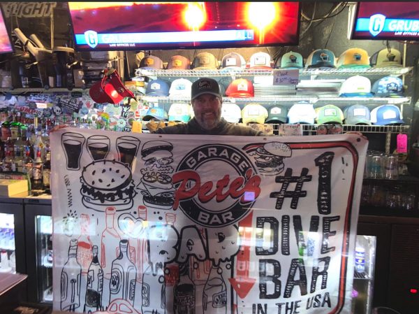 Cassidy Johnson / Advance-Titan -- Peter Haferman, owner of Pete’s Garage Bar, poses with the flag he received for winning.