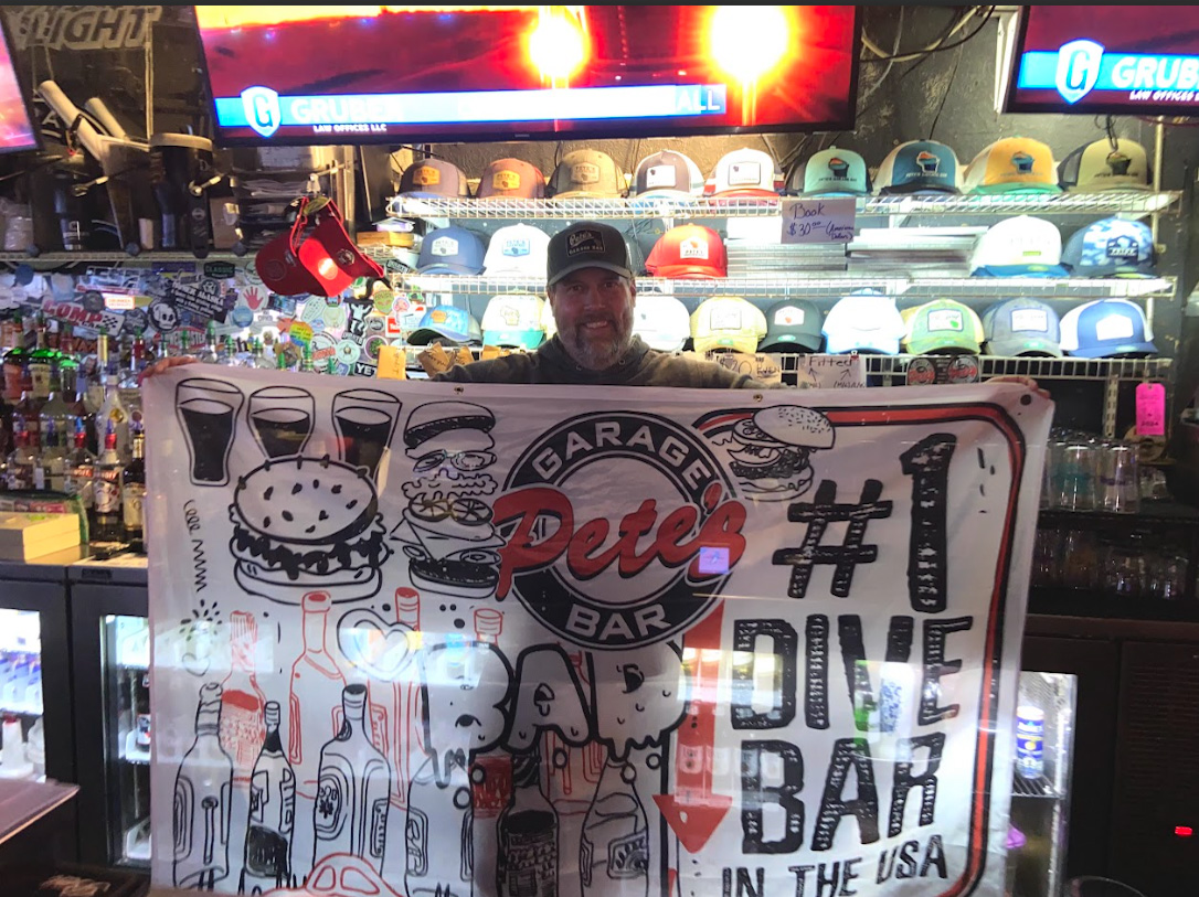Cassidy Johnson / Advance-Titan -- Peter Haferman, owner of Pete’s Garage Bar, poses with the flag he received for winning.