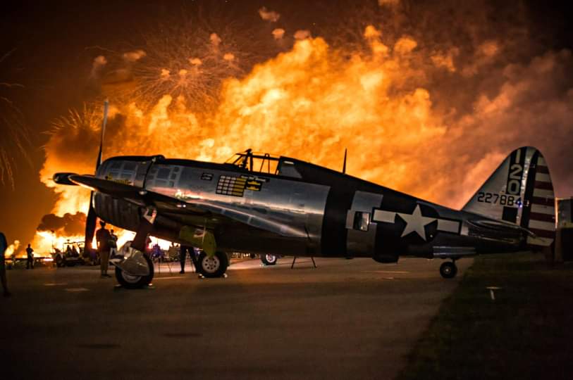 Isaac Pischer / Advance-Titan -- A P-47 Thunderbolt poses during a night air show finale during EAA AirVenture in 2023. EAA AirVenture Oshkosh 2025 will be held July 21-27 at the Wittman Regional Airport.