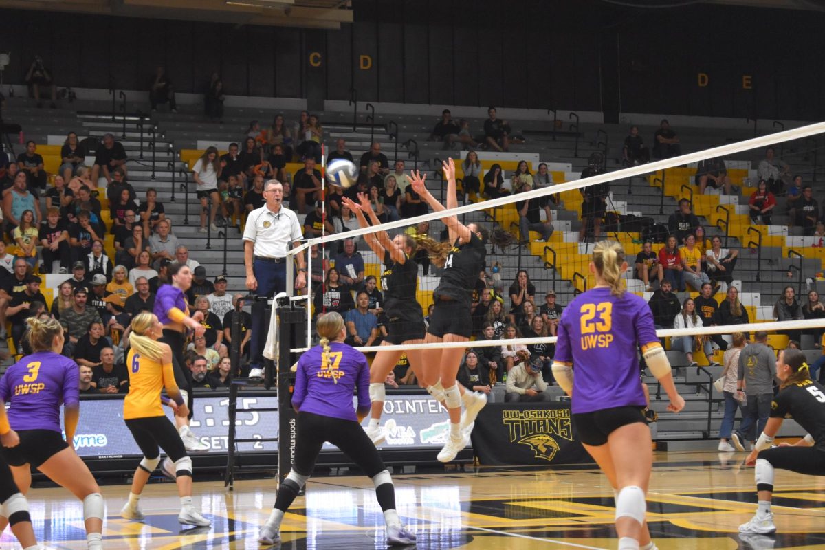 Nolan Andler / Advance-Titan – Lauren Grier (14) and Maren Motz (18) try to block a kill from UWSP. UWO beat the Pointers 3-0 in the third ever Community Night.