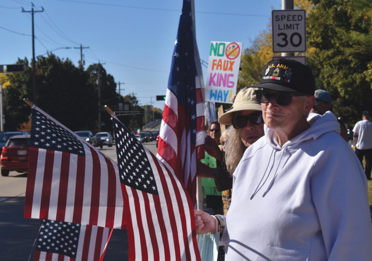 Josh Lehner / Advance-Titan – Protesters hold American flags and signs out toward cars passing along Congress Avenue during the “No Kings” protest Oct. 18 in downtown Oshkosh.