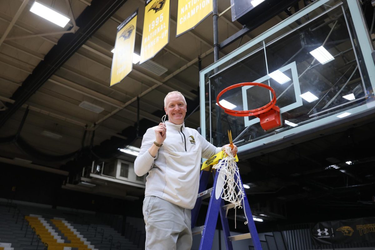 Courtesy of  Steve Frommell / UWO Athletics -
Brad Fischer poses with the net after the Titans clinched a share of the WIAC championship on Feb. 14.
