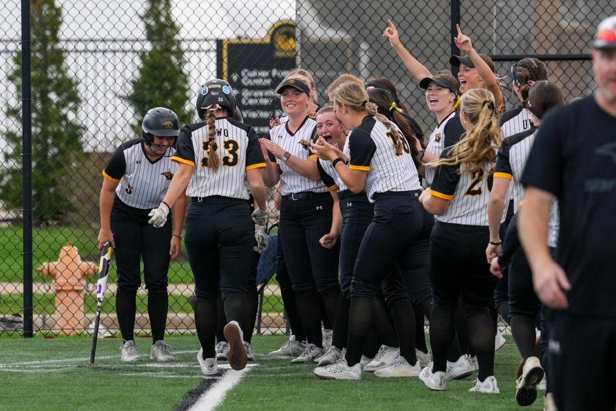 Courtesy of Terri Cole / UWO Athletics -- Mary Kate Quaid is greeted by teammates at home plate after hitting a home run for the Titans on April 17.  