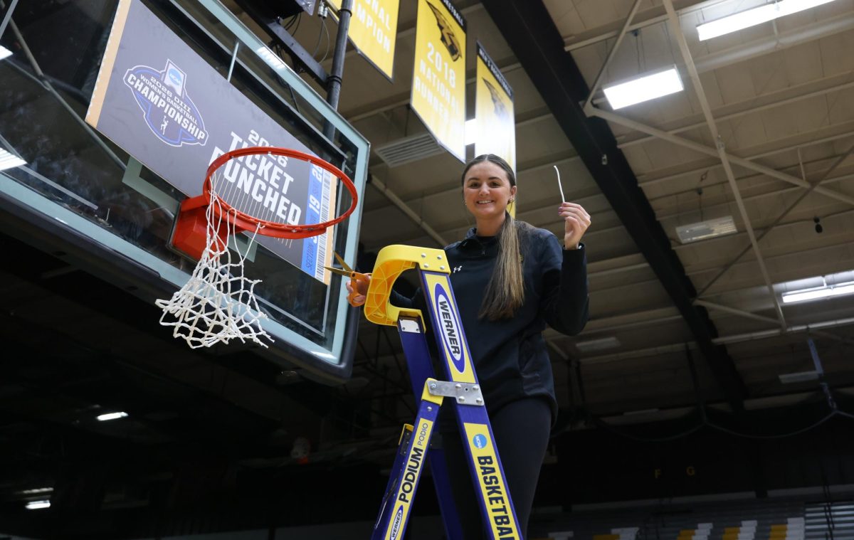 Steve Frommell / UWO Athletics – Cassie Schiltz holds a piece of the basketball net after UW-Oshkosh defeated the University of Chicago (Illinois) in the NCAA Sectional Championship on March 14.